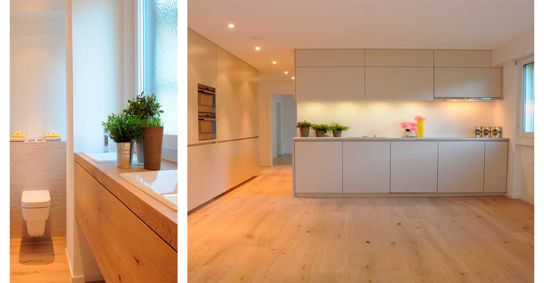 Foto:links Toilette mit Waschtisch aus Bodemholz, rechts: offene Küche beige auf Holzboden
